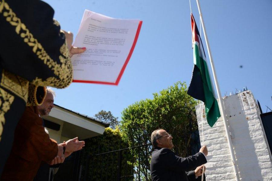 El embajador de Palestina en Uruguay, Walid AbdelRahim, iza la bandera de su estado. // Foto: EFE.