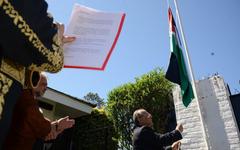 El embajador de Palestina en Uruguay, Walid AbdelRahim, iza la bandera de su estado. // Foto: EFE.