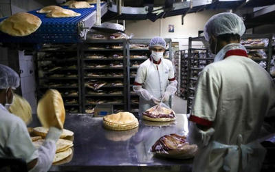 Empleados, con equipo de protección personal, empacan pan en una panadería en la capital libanesa de Beirut. (PATRICK BAZ / AFP) Empleados, con equipo de protección personal, empacan pan en una panadería en la capital libanesa de Beirut. (PATRICK BAZ / AFP)