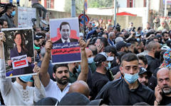 Manifestantes levantan pancartas contra el juez Tarek Bitar, julio de 2021. Foto: AFP.