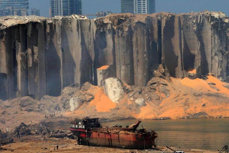 ‎Un silo de grano ahuecado y un barco carbonizado el día después de la explosión en el puerto de Beirut.‎ Foto: AFP.