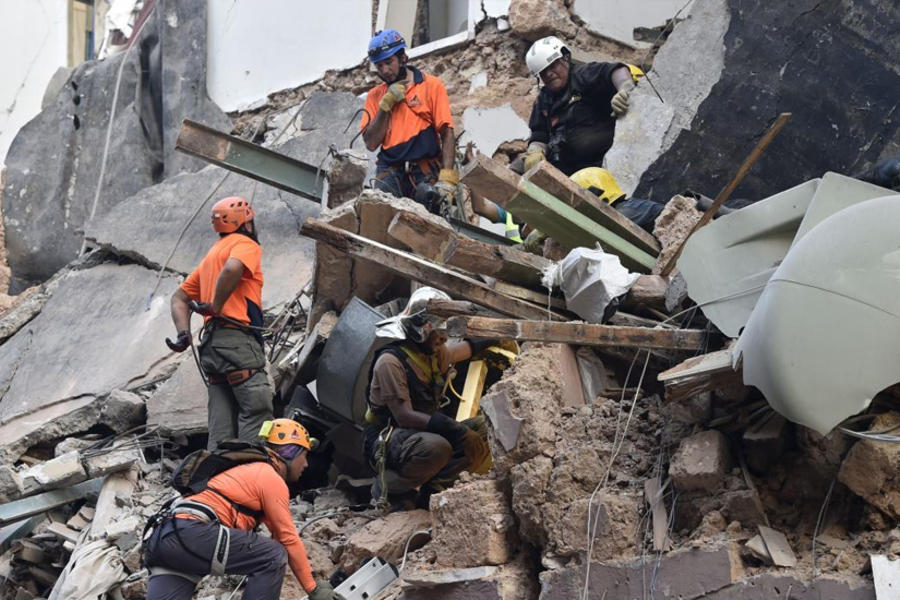 Miembros de un equipo de rescate entre escombros en Beirut. AFP.