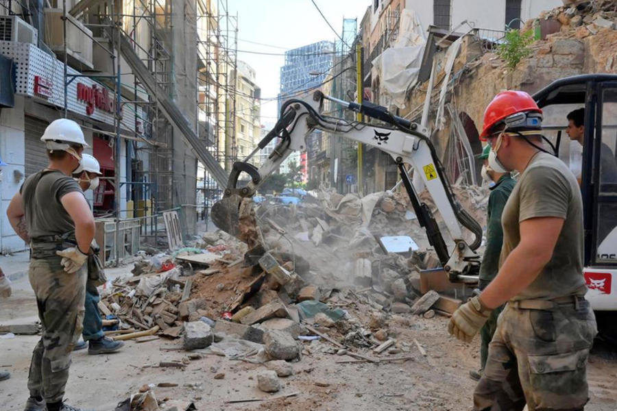 Personal de mantenimiento de la paz de la ONU ayuda a limpiar las ruinas del vecindario Mar Mikhael de Beirut, luego de la explosión masiva del puerto en agosto. 
