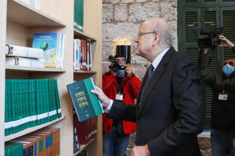 El primer ministro Najib Mikati hojea los libros durante la ceremonia de reapertura de la Biblioteca Nacional en Beirut, el 10 de febrero de 2022, una vez finalizados los trabajos de restauración después de la explosión del puerto de verano de 2020. Foto: AFP.