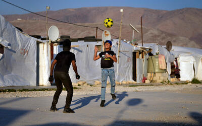 Niños juegan al fútbol en un campo de refugiados en la ciudad de Bar Elias, en el valle de Bekaa, Líbano, el 7 de julio de 2022. Foto: AP.