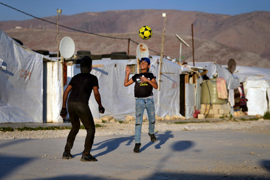 Niños juegan al fútbol en un campo de refugiados en la ciudad de Bar Elias, en el valle de Bekaa, Líbano, el 7 de julio de 2022. Foto: AP.