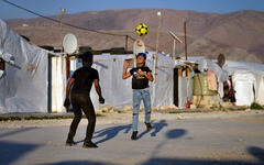 Niños juegan al fútbol en un campo de refugiados en la ciudad de Bar Elias, en el valle de Bekaa, Líbano, el 7 de julio de 2022. Foto: AP.