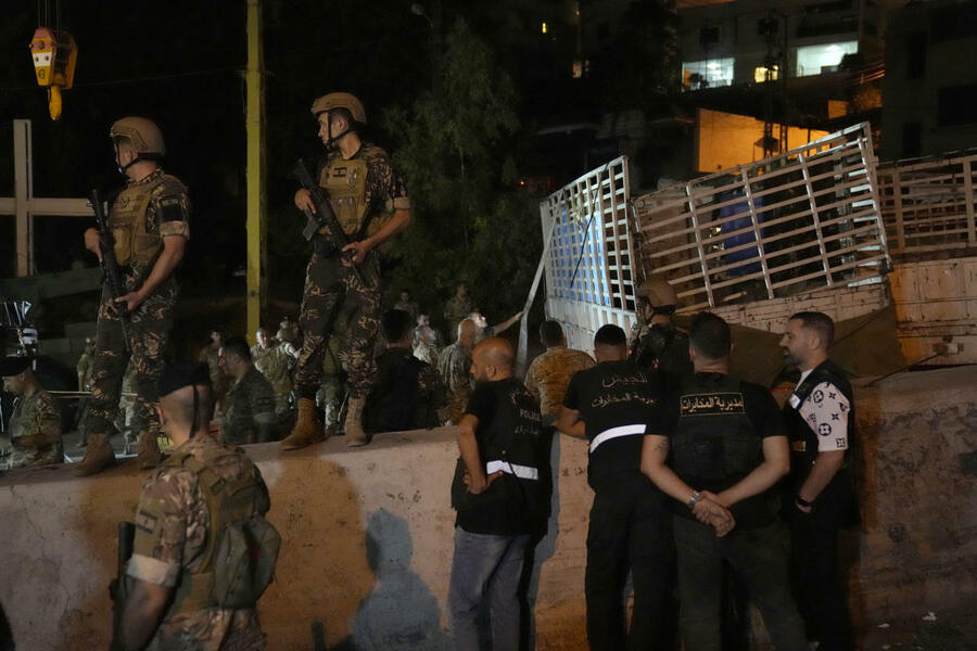 Soldados libaneses montan guardia junto a un camión volcado, a la derecha, en la ciudad cristiana de Al-Khaila, Líbano, el miércoles 9 de agosto de 2023. Foto: AP.