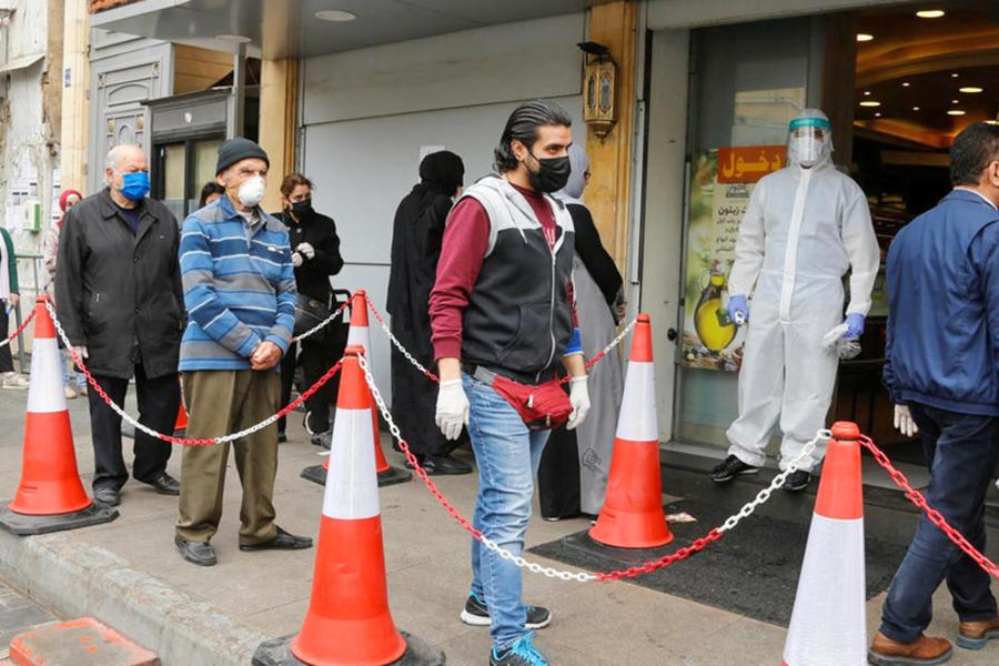 Clientes usan máscaras faciales y guantes afuera de un supermercado en Beirut, Líbano. (REUTERS).