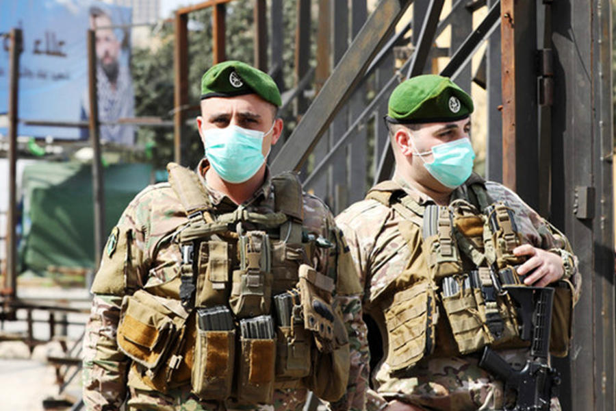 Soldados libaneses de guardia en el distrito del centro de la capital, Beirut, usan máscaras protectoras contra el coronavirus. (AFP)