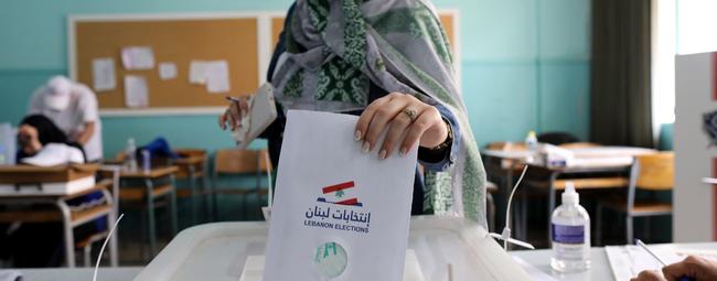 Un trabajador electoral muestra una a los representantes de los candidatos parlamentarios, después del cierre de un colegio electoral, en Beirut, Líbano, el domingo. Foto: AFP.