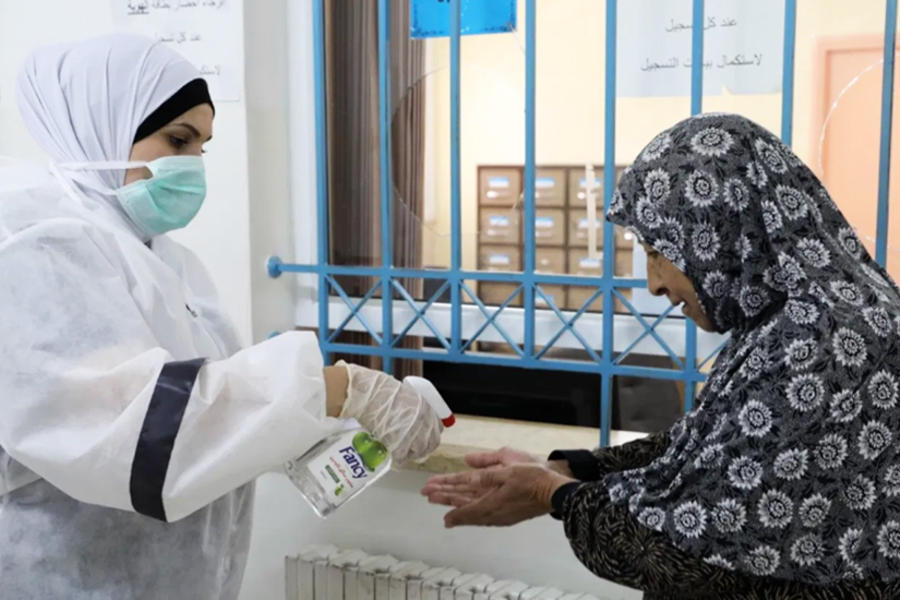 Un miembro del personal de salud del UNRWA asiste a una paciente refugiada palestina. Foto: UNRWA.