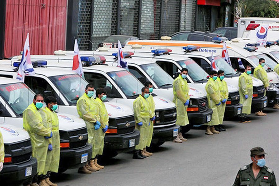 Personal de salud usa el equipo de protección cerca de las ambulancias, como parte de la preparación para ayudar a combatir el brote de la enfermedad por coronavirus. (AFP)