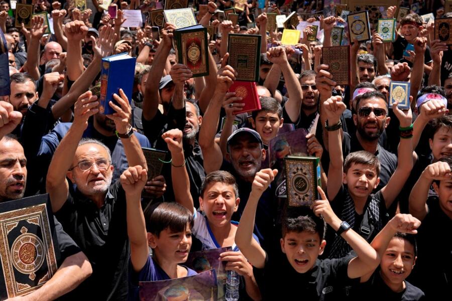 Libaneses cantan consignas mientras sostienen el Corán durante una manifestación después de las oraciones del viernes en el suburbio de Dahiyeh, en el sur de Beirut, Líbano, el viernes 21 de julio de 2023. Foto: AP.