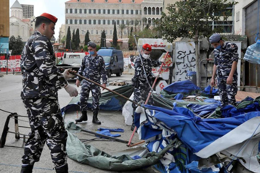 Las fuerzas de seguridad libanesas derriban las carpas mientras limpian un campamento de protesta. REUTERS.