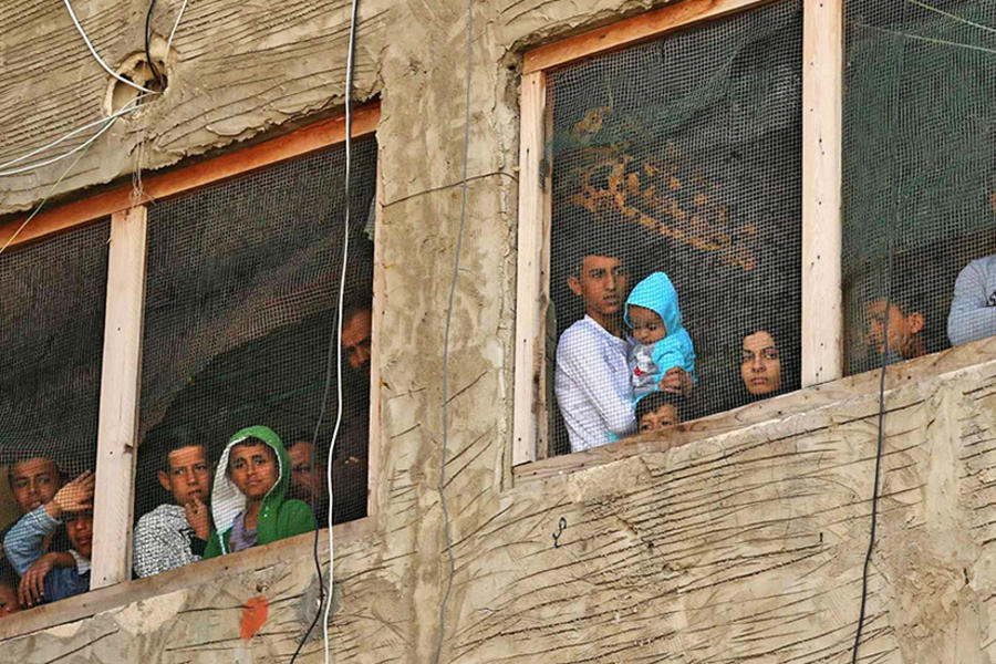 Refugiados sirios en un edificio en construcción que han estado utilizando como refugio en una ciudad en el sur del Líbano, el 17 de marzo de 2020, después de que Líbano instó a las personas a quedarse en casa durante dos semanas para detener un nuevo brote de coronavirus. AFP.