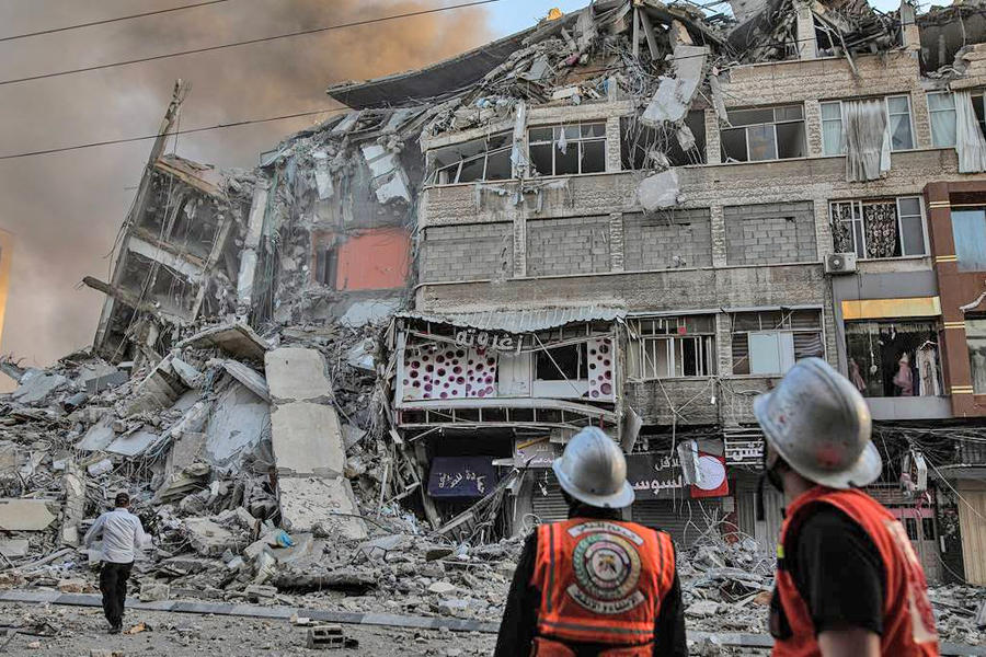 Funcionarios inspeccionan los edificios dañados en la ciudad de Gaza luego de un ataque aéreo israelí el 12 de mayo de 2021 en la Franja de Gaza. Foto: AFP.