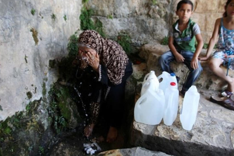 Una mujer palestina llena un bidón con agua de manantial en Salfit, al norte de Ramallah.