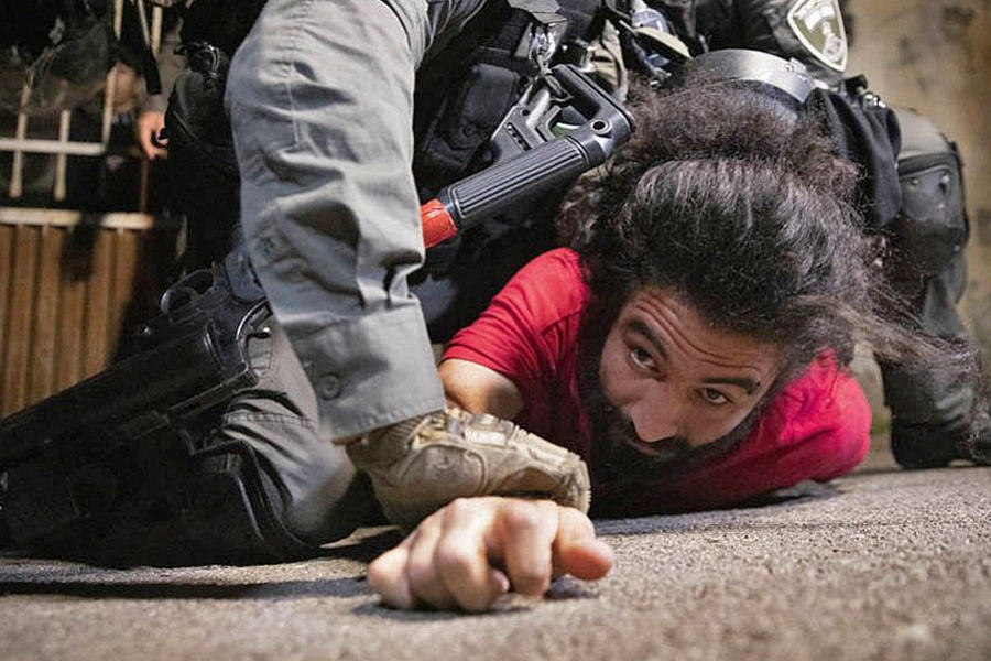 La policía israelí golpea a un residente palestino de Sheikh Jarrah durante una vigilia contra los próximos desalojos en el vecindario, el 4 de mayo de 2021. (Oren Ziv)