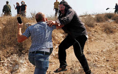 Un manifestante palestino se pelea con un colono israelí durante una protesta contra los asentamientos. Foto: Reuters.