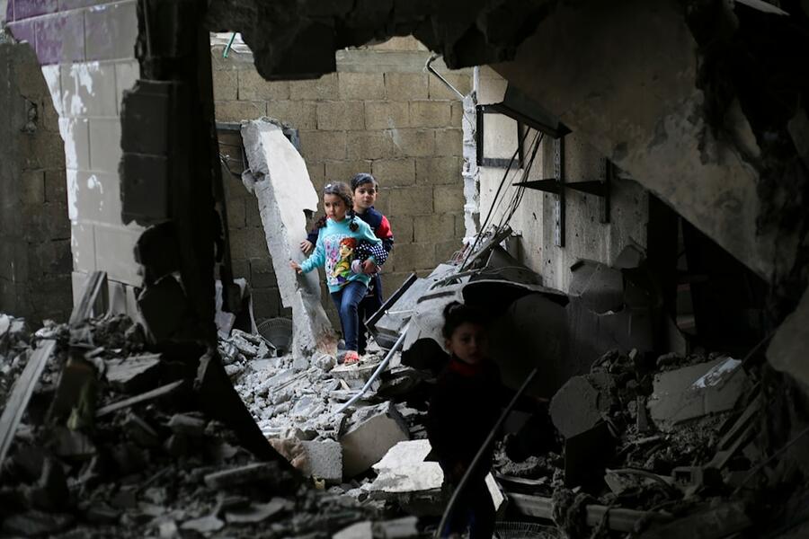 Niños palestinos caminan entre escombros tras un ataque del régimen israelí a edificios residenciales en Rafah, Franja de Gaza | Diciembre 14, 2023 (Foto: AP)