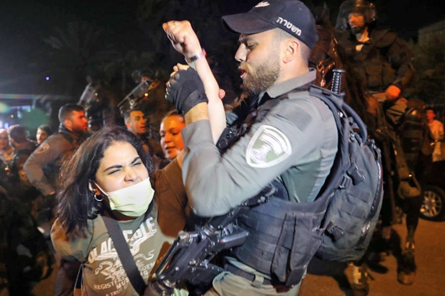 Una mujer palestina se pelea con la policía israelí durante una protesta contra los desalojos previstos de familias palestinas en el barrio de Sheikh Jarrah. Foto: EFE.