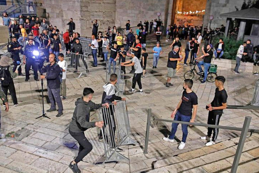 Los manifestantes palestinos eliminan las barreras metálicas en la Puerta de Damasco, Jerusalén. Foto: AFP.