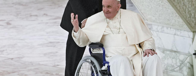 El papa Francisco llega en silla de ruedas para asistir a una audiencia con monjas y superiores religiosos en el Aula Pablo VI del Vaticano, el 5 de mayo de 2022. Foto: AP.