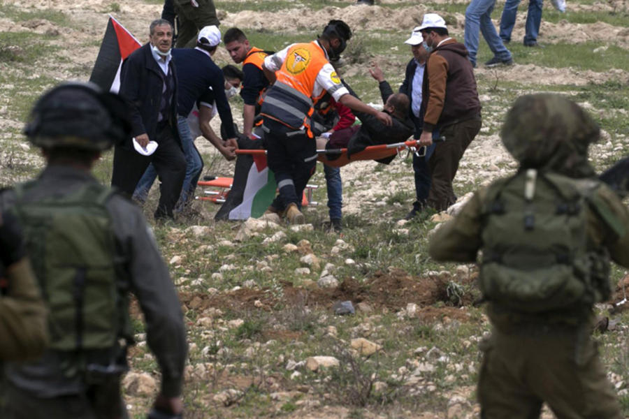 Manifestantes palestinos transportan a un herido en los enfrentamientos con las fuerzas israelíes en la conmemoración del Día de la Tierra en la aldea de Madama, Palestina ocupada, Marzo 30, 2017.