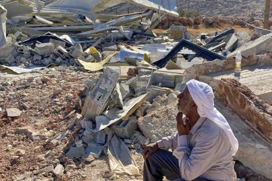 Un hombre se sienta en medio de las ruinas de la mezquita de Abu Saif demolida en la ciudad cisjordana de Duma. Foto: Mosab Dawabsheh.