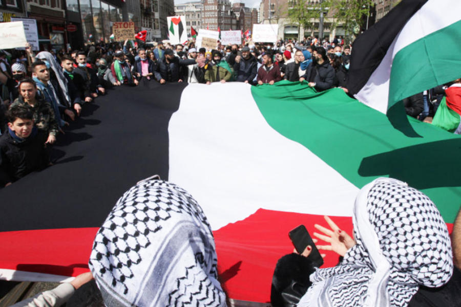 Manifestantes flamean bandera palestina en protesta. Foto: AFP.