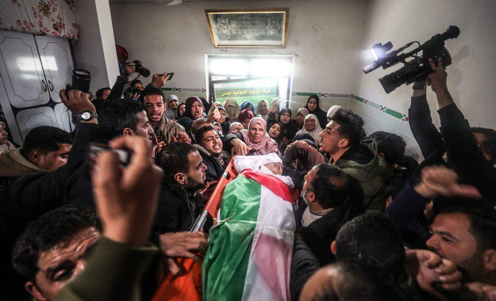 Familiares llevan el cuerpo de Hassan Shalabi, de 14 años, durante su funeral en el campamento de refugiados de Nusseirat | Gaza, febrero 9, 2019 (Foto: Mustafa Hassona / Anadolu)