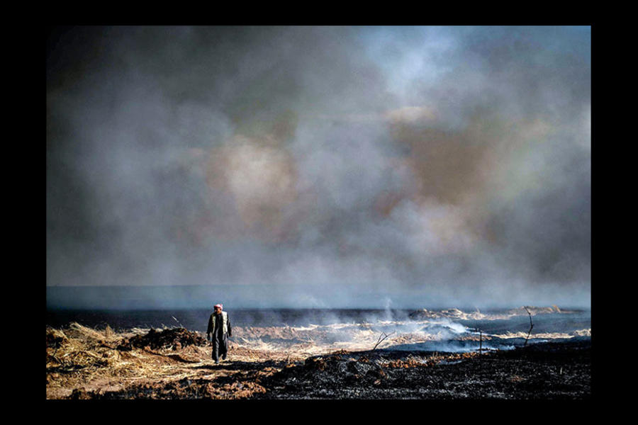 Un habitante local camina por un área incendiada en un campo agrícola en la ciudad de al-Qahtaniyah (provincia de Hasaka), cerca de la frontera sirio-turca (Foto AFP)