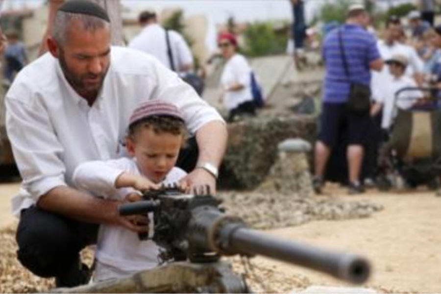 Colono israelí en plena educación sionista de su hijo.