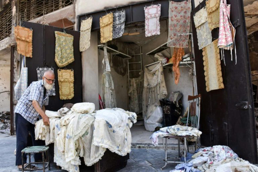 Abu Sabeih en su negocio en el zoco de la Ciudad Vieja de Alepo, rodeado por la destrucción de la guerra terrorista | Julio 2017 (Imagen: George Ourfalian / AFP). 