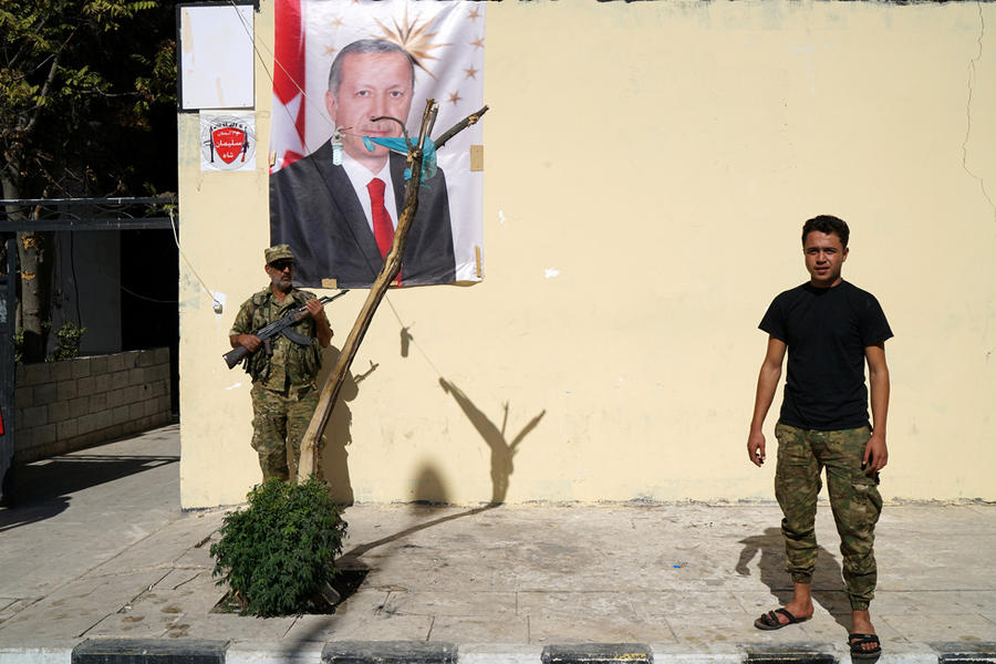 Miembros de Ejército Libre Sirio (FSA), sostenido por Turquía, parados frente a la pared con retrato del presidente turco Erdogan, en la ciudad fronteriza de Jarablus, Siria, octubre 19, 2016 (Foto REUTERS/Umit Bektas).