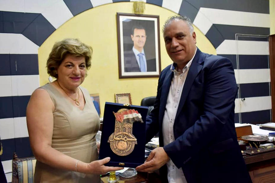 La Presidenta de las Damas Sirias de Chile Marlene Haddad recibe un galvano de manos del Gobernador de Homs Talal Barazi