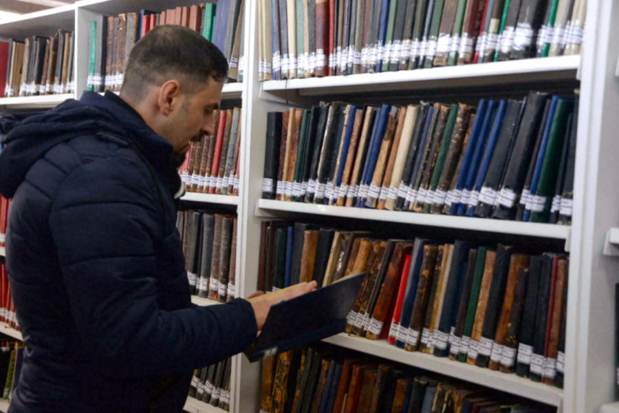 Un hombre inspecciona un libro en la biblioteca de Mosul, el 31 de enero de 2022 (Foto: Zaid Al-Obaidi /AFP)