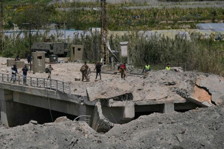 Soldados y civiles libaneses cruzan a pie el puente Qasmiyeh, tras su destrucción por el ejército israelí, este jueves en Líbano. Foto: AP.