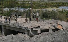 Soldados y civiles libaneses cruzan a pie el puente Qasmiyeh, tras su destrucción por el ejército israelí, este jueves en Líbano. Foto: AP.