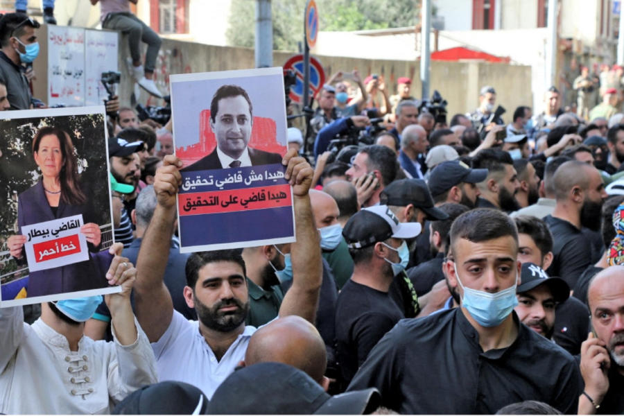 Manifestantes levantan pancartas contra el juez Tarek Bitar, julio de 2021. Foto: AFP.