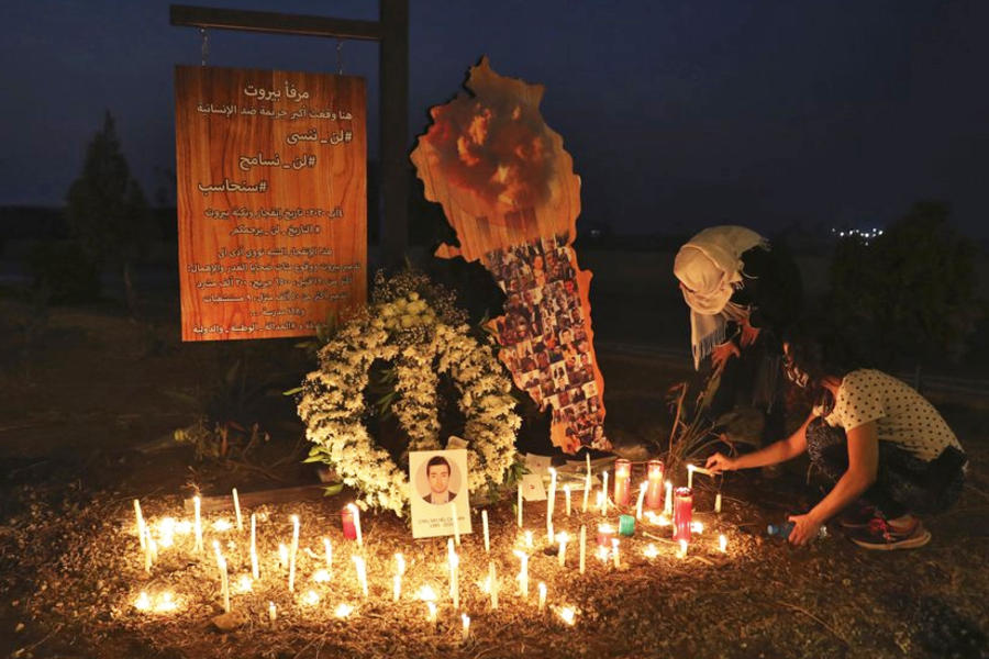 Libaneses encienden velas cerca del puerto marítimo de Beirut, el viernes 4 de septiembre de 2020. AFP.
