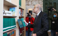 El primer ministro Najib Mikati hojea los libros durante la ceremonia de reapertura de la Biblioteca Nacional en Beirut, el 10 de febrero de 2022, una vez finalizados los trabajos de restauración después de la explosión del puerto de verano de 2020. Foto: AFP.