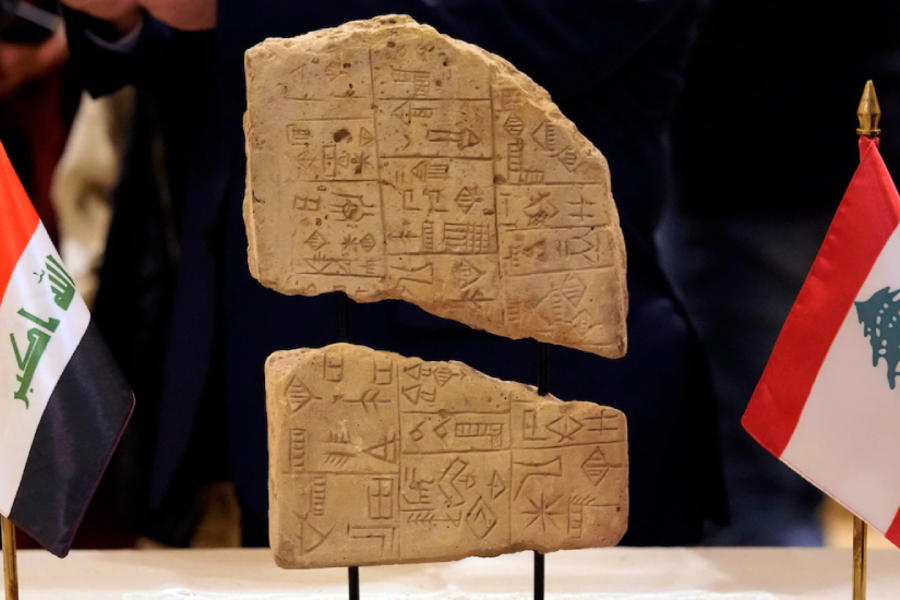 ‎Una tablilla de arcilla iraquí se exhibe entre una bandera libanesa y una bandera iraquí durante una ceremonia celebrada en el Museo Nacional de Beirut. Foto: AP.