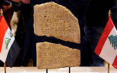 ‎Una tablilla de arcilla iraquí se exhibe entre una bandera libanesa y una bandera iraquí durante una ceremonia celebrada en el Museo Nacional de Beirut. Foto: AP.