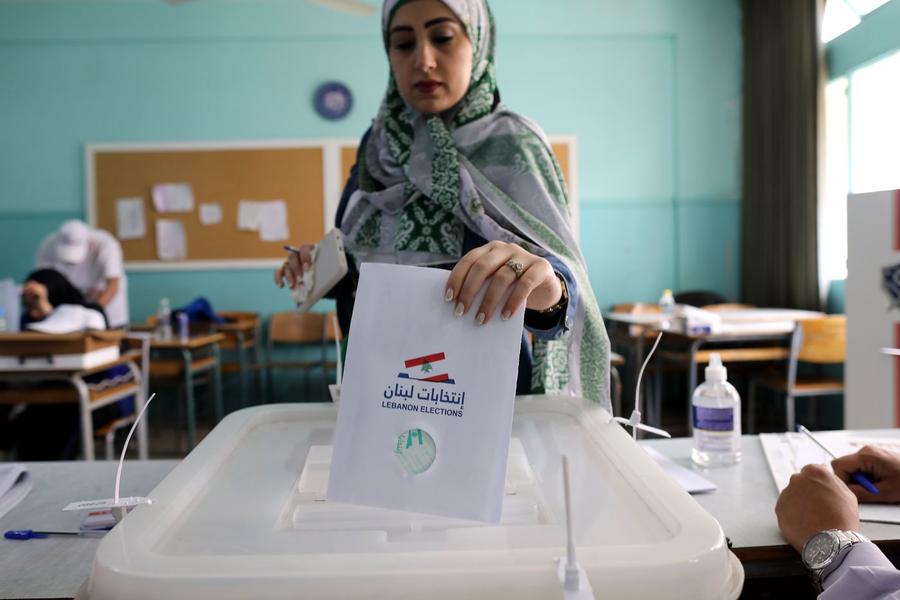 Un trabajador electoral muestra una a los representantes de los candidatos parlamentarios, después del cierre de un colegio electoral, en Beirut, Líbano, el domingo. Foto: AFP.