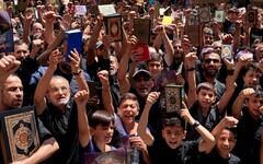 Libaneses cantan consignas mientras sostienen el Corán durante una manifestación después de las oraciones del viernes en el suburbio de Dahiyeh, en el sur de Beirut, Líbano, el viernes 21 de julio de 2023. Foto: AP.