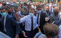 El presidente francés, Emmanuel Macron, con camisa blanca, saluda a la gente del barrio de Gemmayzeh en Beirut, Líbano. Imágenes de AFP / Getty