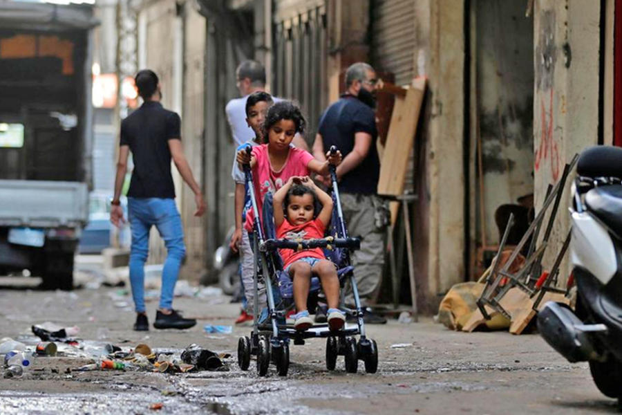Una niña empuja un cochecito a lo largo de un callejón en el barrio Bab Al Tabbaneh, en la ciudad norteña de Trípoli, Líbano, el 3 de junio de 2020. AFP.