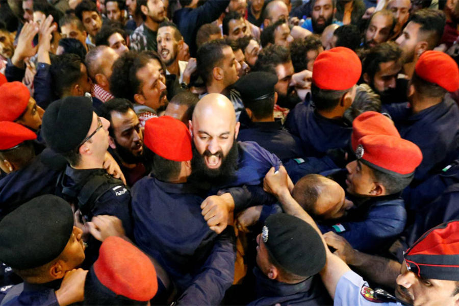 Policías chocan con manifestantes junto a la oficina del primer ministro, el domingo en Ammán (Foto Muhammad Hamed / Reuters).